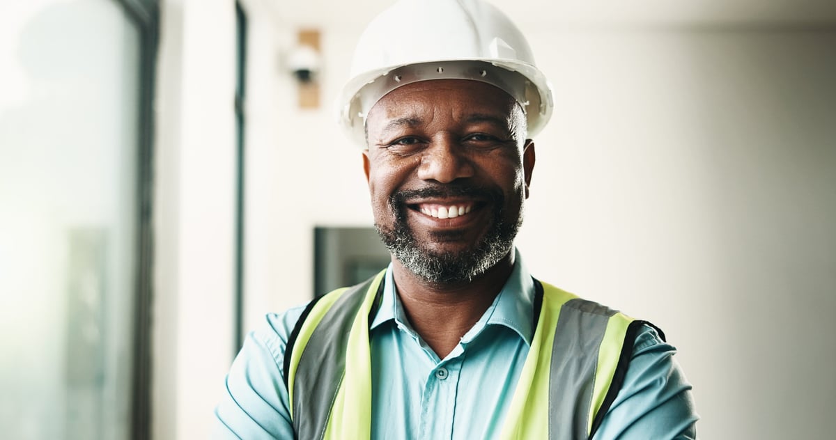 Black construction contractor smiling confidently on a renovation site